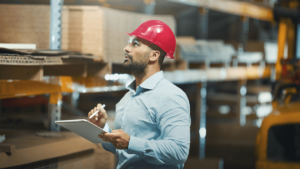 a man in a red hard hat holding a clipboard